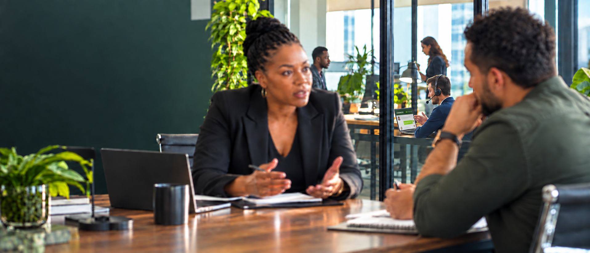 A professional uses LeadCeptional on his laptop to practice a simulated leadership conversation while a coaching conversation remains visible in the foreground.